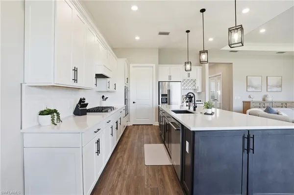 a kitchen with kitchen island a sink appliances and cabinets