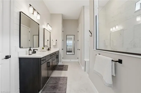 a spacious bathroom with a double vanity sink mirror double and shower