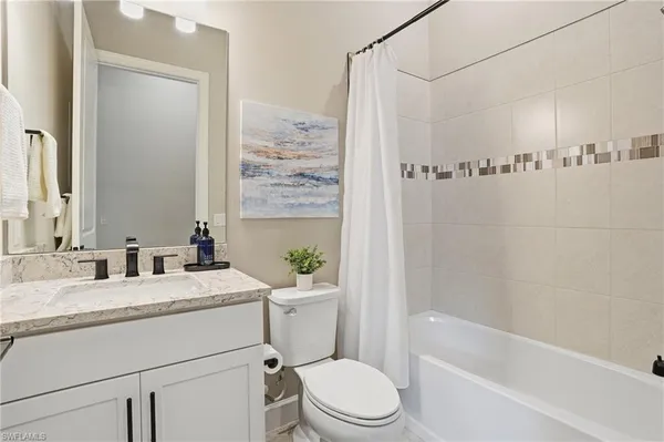a bathroom with a granite countertop sink a toilet and shower
