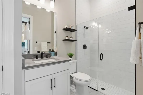 a bathroom with a sink a toilet and shower