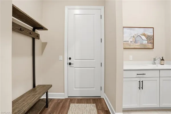 a view of a hallway with wooden floor and closet