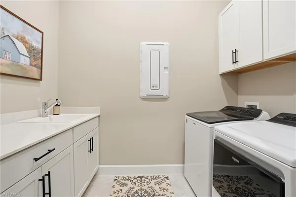 a utility room with sink dryer and washer