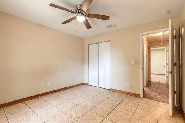 an empty room and chandelier fan