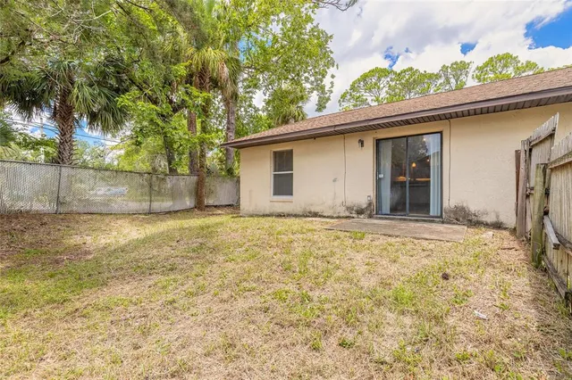 a view of a house with a backyard and a tree