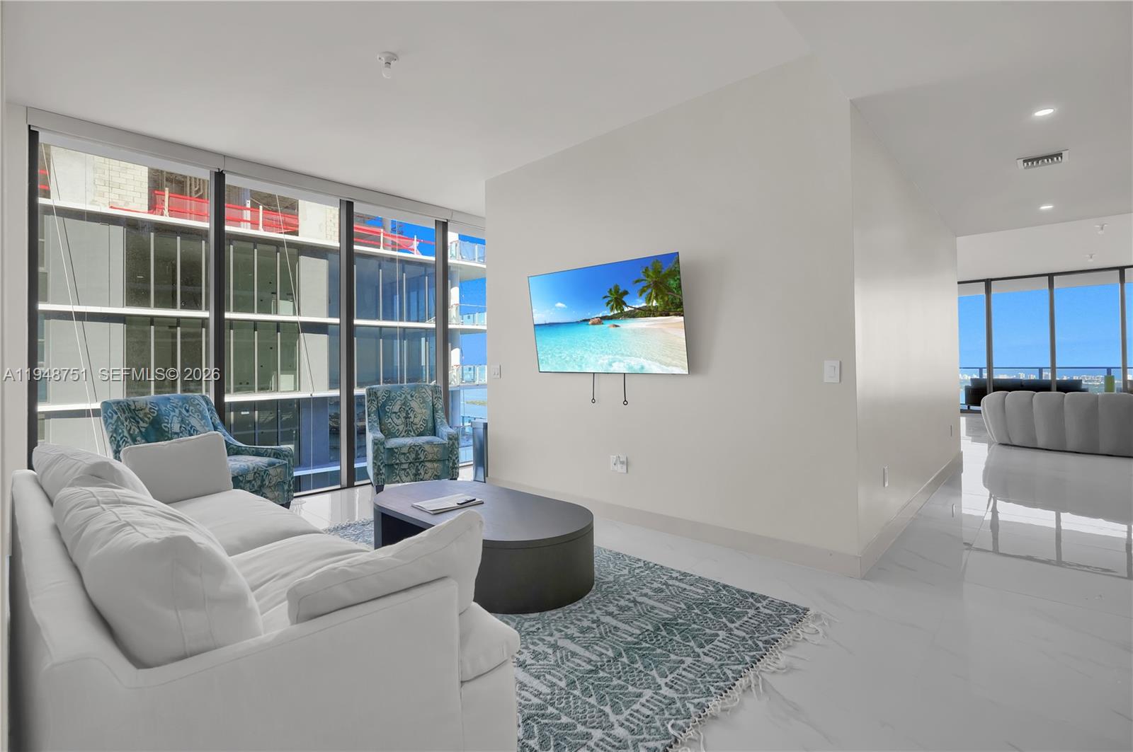700 Northeast 24th Street, Unit PH5801 Miami, FL 33137 - Photo 21 of 81 a living room with furniture a flat screen tv and a floor to ceiling window