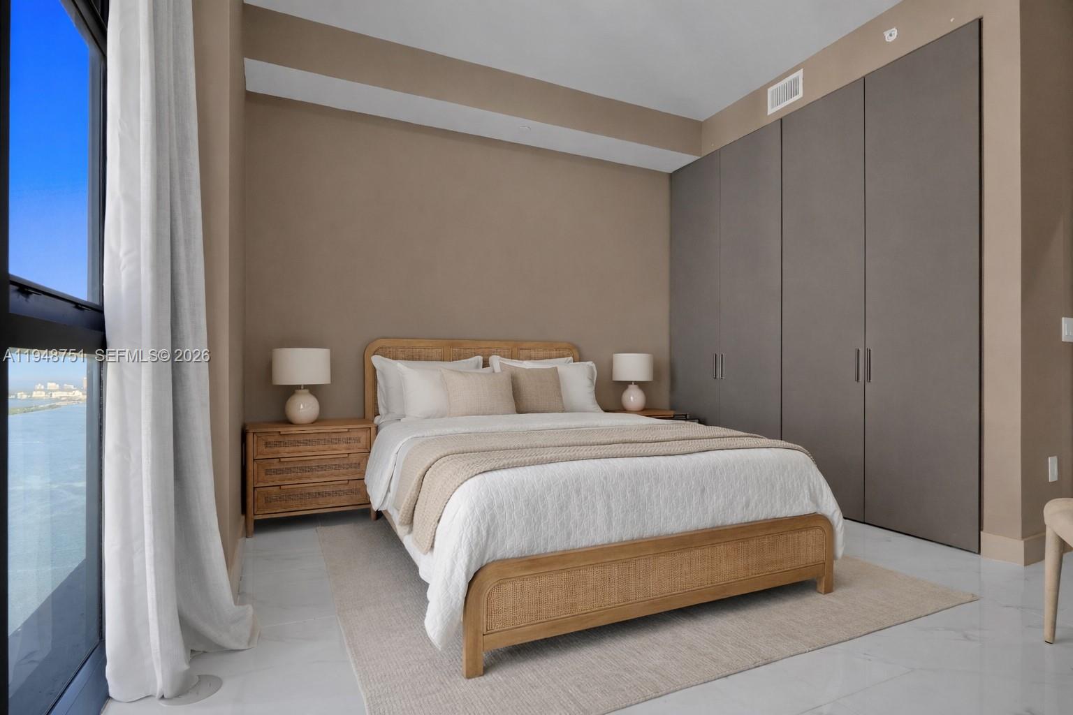 700 Northeast 24th Street, Unit PH5801 Miami, FL 33137 - Photo 31 of 81 a bedroom with a bed and a night stand