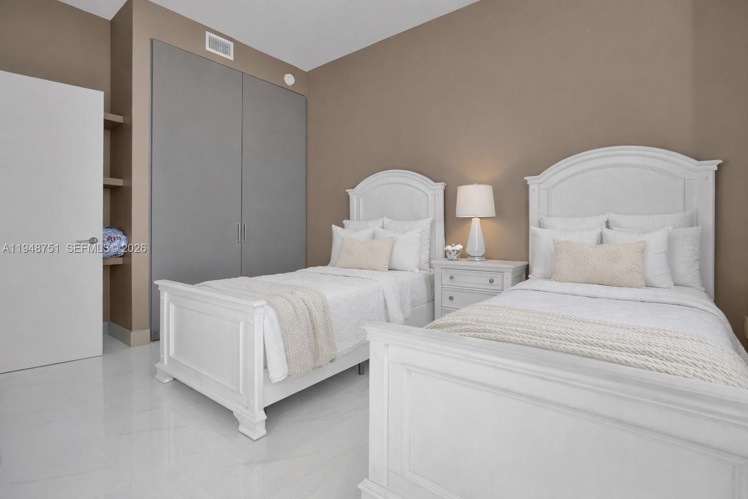 700 Northeast 24th Street, Unit PH5801 Miami, FL 33137 - Photo 34 of 81 a bedroom with two beds and a chandelier