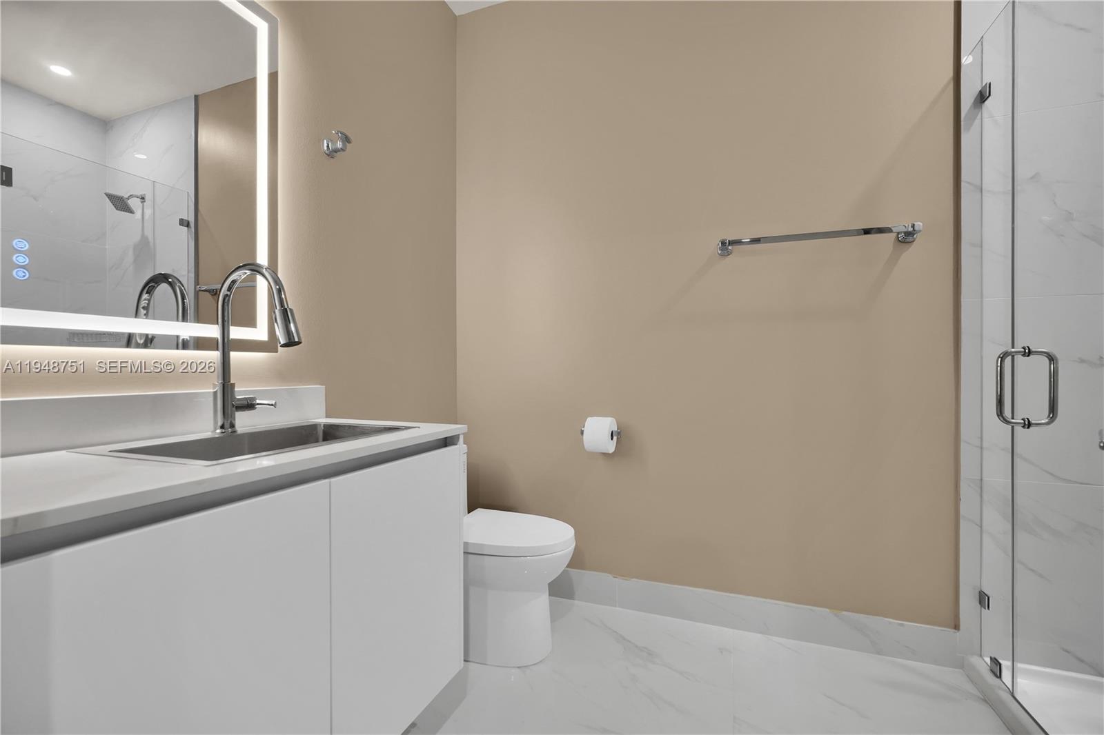 700 Northeast 24th Street, Unit PH5801 Miami, FL 33137 - Photo 40 of 81 a bathroom with a granite countertop sink a toilet and a mirror