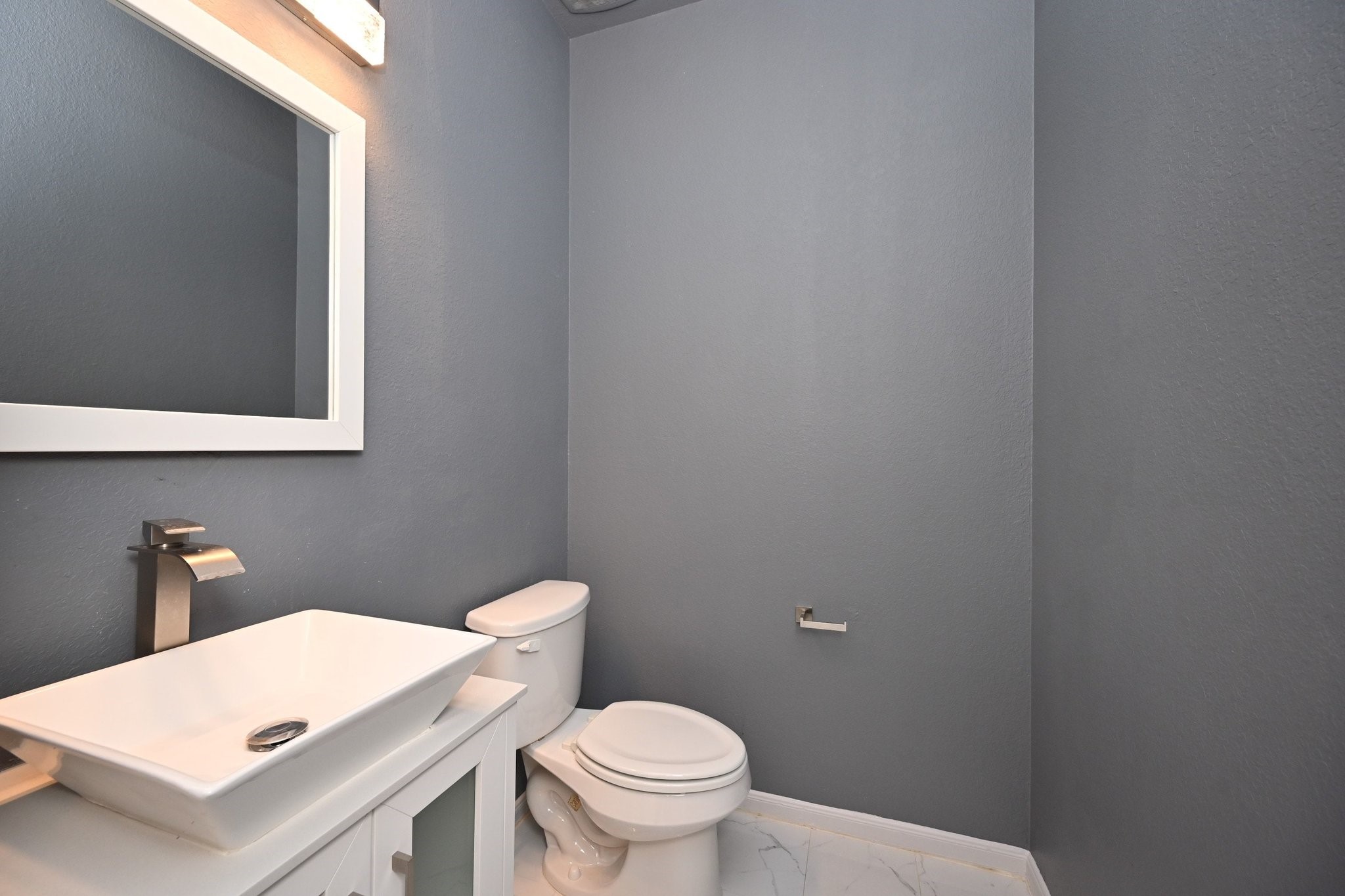 21119 Keystone Pine Court Katy, TX 77449 - Photo 12 of 43 a white toilet sitting next to a bathroom sink