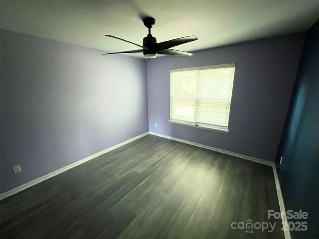 an empty room with a window and a ceiling fan