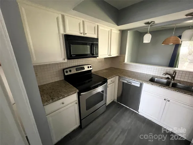 a kitchen with a sink and a stove top oven