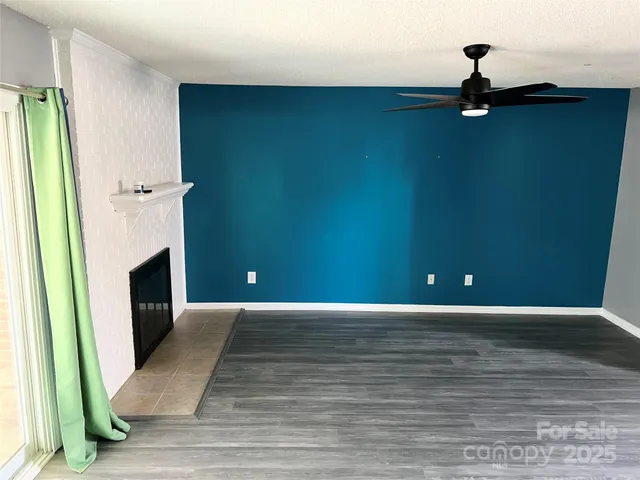 a view of a livingroom with wooden floor and a fireplace