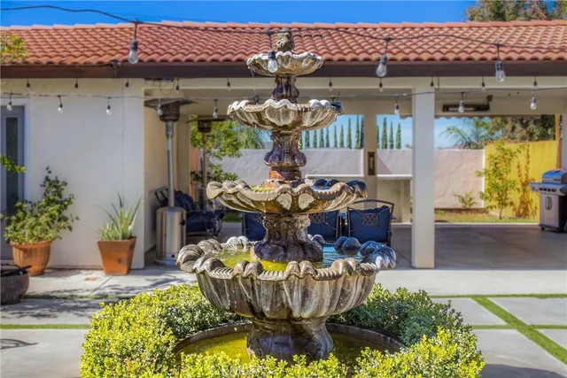 a view of a house with backyard water fountain and sitting area
