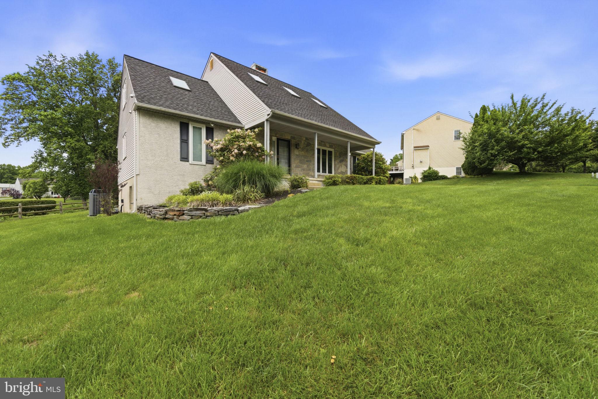 736 Letitia Drive Hockessin, DE 19707 - Photo 6 of 92 a front view of a house with a garden and trees
