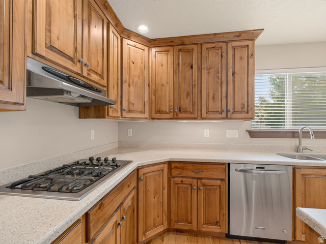 1279 West 1500th Street North Mapleton, UT 84664 - Photo 22 of 83 Kitchen featuring wood cabinetry, light speckled countertops, and stainless steel appliances including a gas cooktop, range hood, and dishwasher
