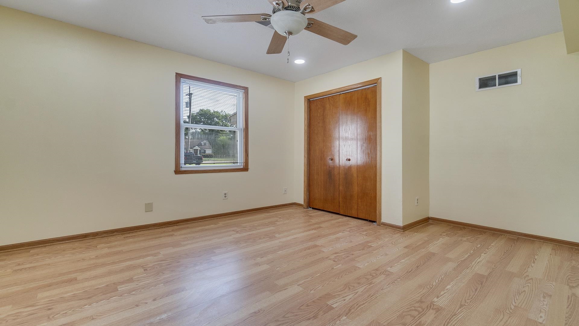 820 East Riverside Boulevard Loves Park, IL 61111 - Photo 12 of 32 an empty room with wooden floor chandelier fan and windows
