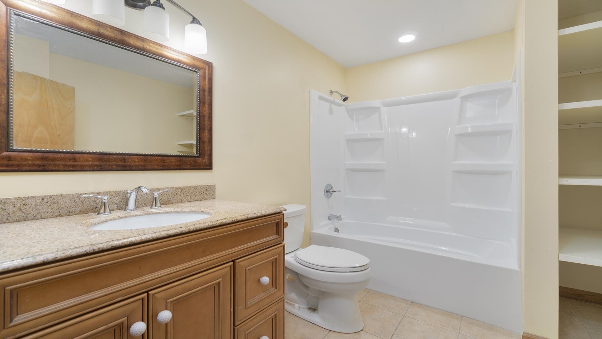 820 East Riverside Boulevard Loves Park, IL 61111 - Photo 14 of 32 a bathroom with a bathtub shower sink vanity mirror and toilet