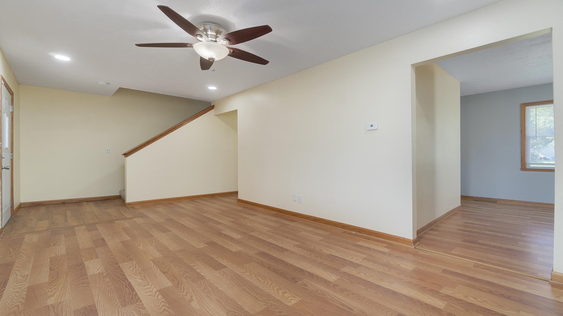 820 East Riverside Boulevard Loves Park, IL 61111 - Photo 7 of 32 an empty room with wooden floor and ceiling fan