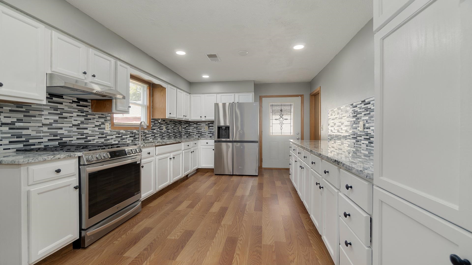 820 East Riverside Boulevard Loves Park, IL 61111 - Photo 8 of 32 a kitchen with granite countertop white cabinets and white appliances
