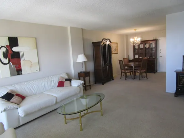 a living room with furniture and a dining table with rug