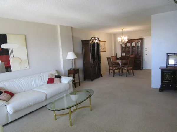 a living room with furniture and a dining table with wooden floor