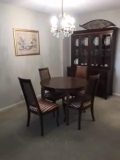 a view of a dining room with furniture and chandelier