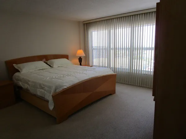 a bed sitting in a spacious bedroom next to a window