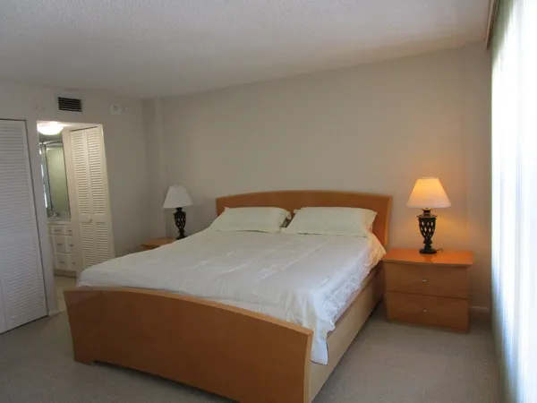 a bed sitting in a bedroom next to a bathroom