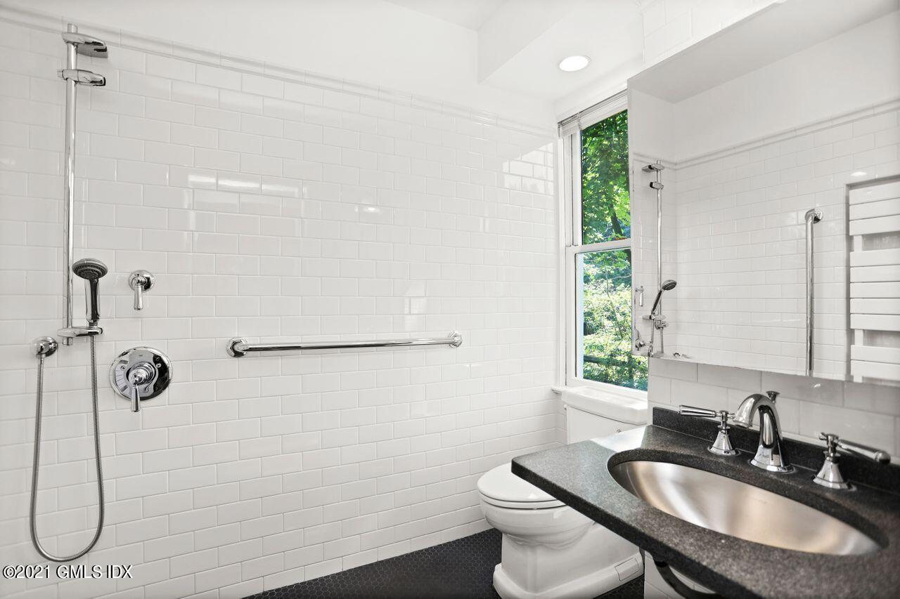 27 Sachem Road Greenwich, CT 06830 - Photo 15 of 50 a bathroom with a sink toilet a mirror and shower