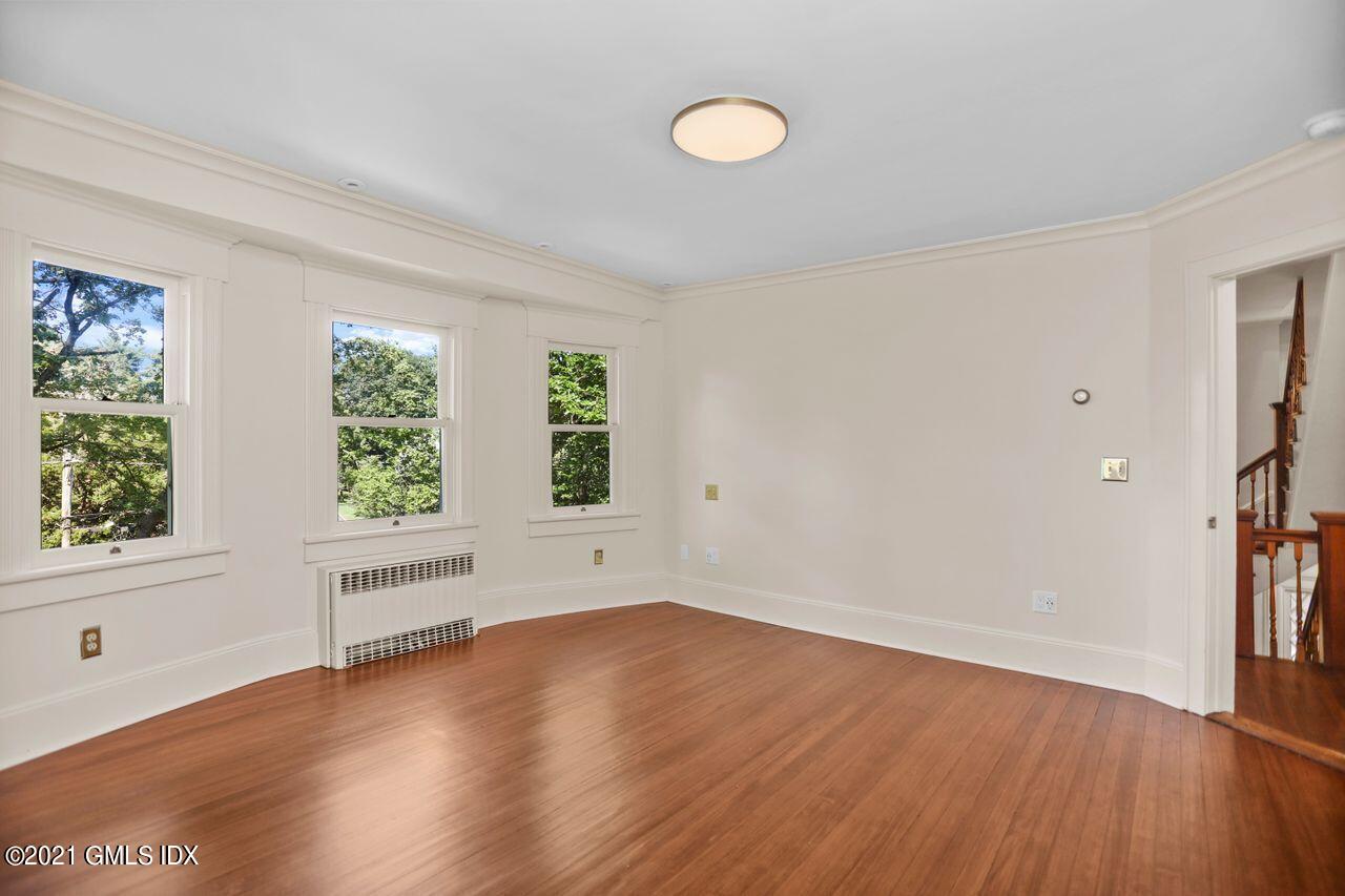27 Sachem Road Greenwich, CT 06830 - Photo 19 of 50 an empty room with wooden floor and windows