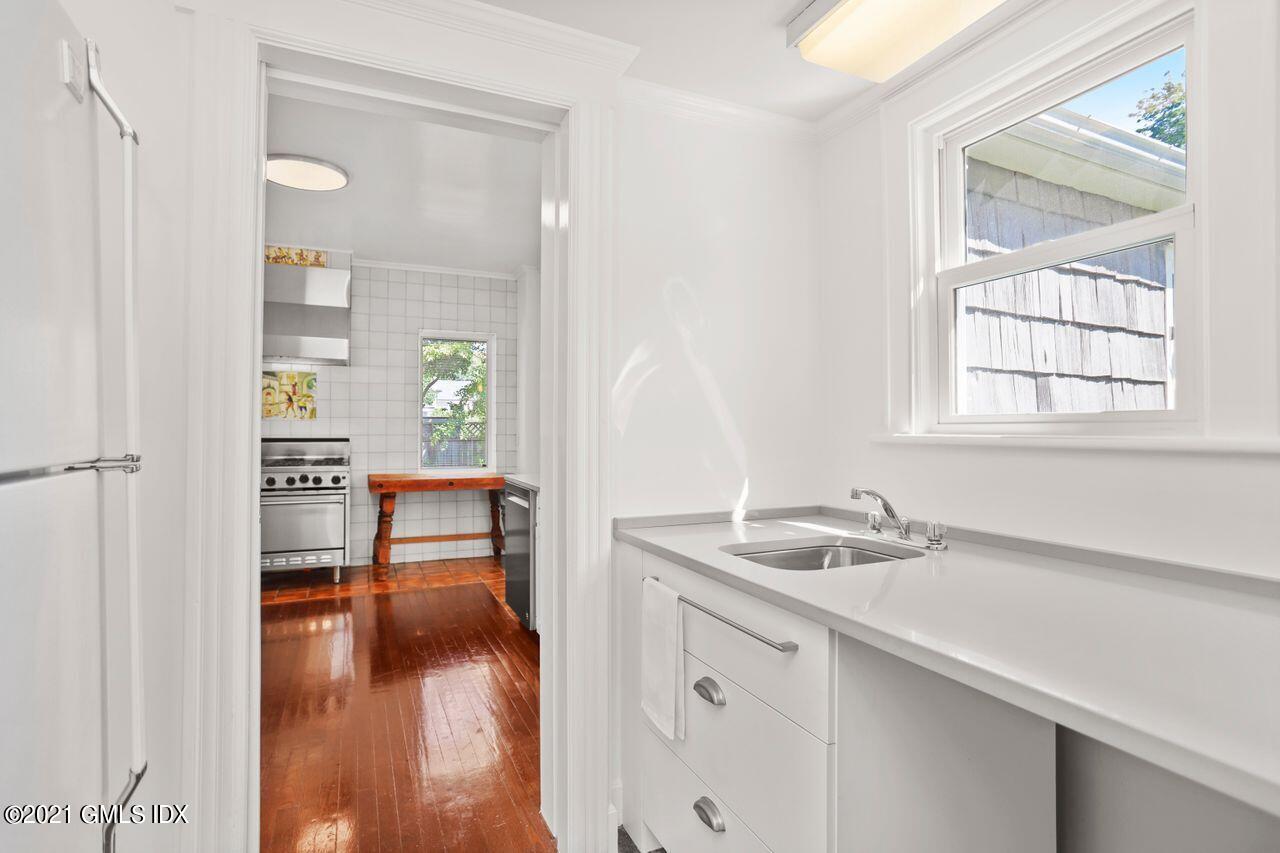 27 Sachem Road Greenwich, CT 06830 - Photo 6 of 50 a hallway with a sink and cabinets