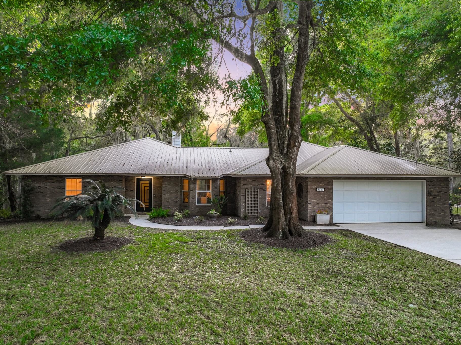 a front view of house with yard and trees