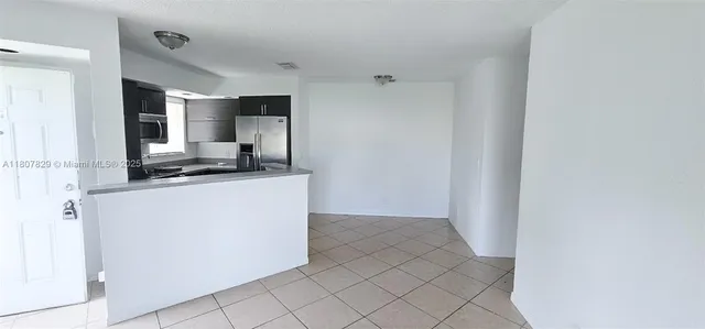 a kitchen with kitchen island white cabinets and refrigerator