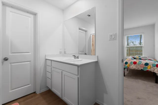 a kitchen with a sink wooden floor and stainless steel appliances
