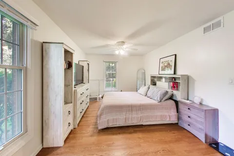 a bedroom with a bed and wooden floor