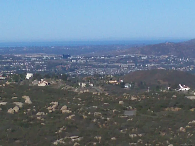 an aerial view of house with yard and mountain view in back