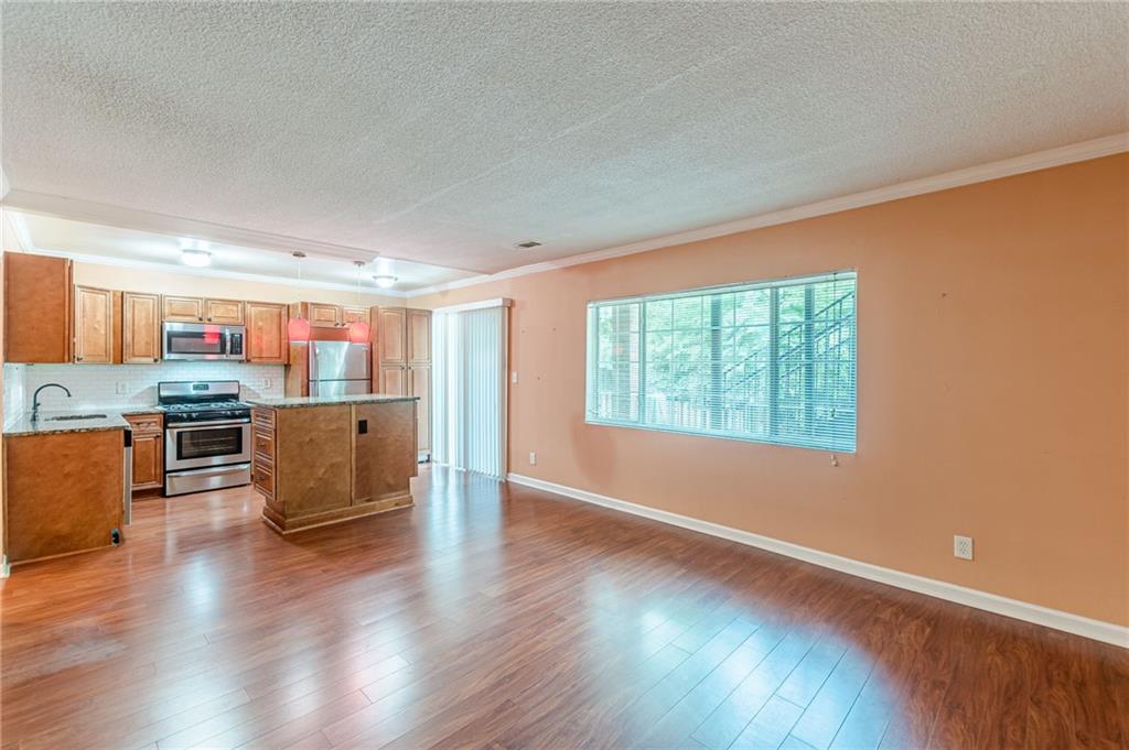 1705 Monroe Drive Northeast, Unit C05 Atlanta, GA 30324 - Photo 15 of 29 a living room with stainless steel appliances kitchen island granite countertop a stove top oven a sink and a wooden floor