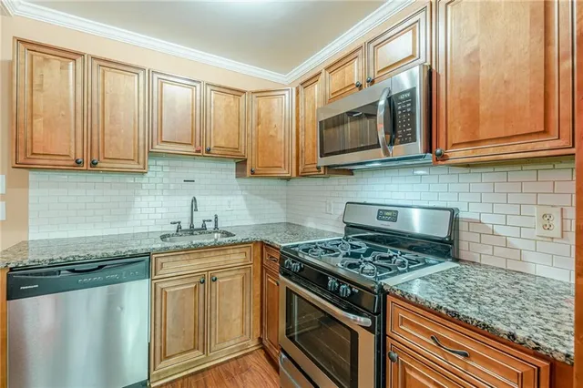 a kitchen with stainless steel appliances granite countertop a sink stove and microwave