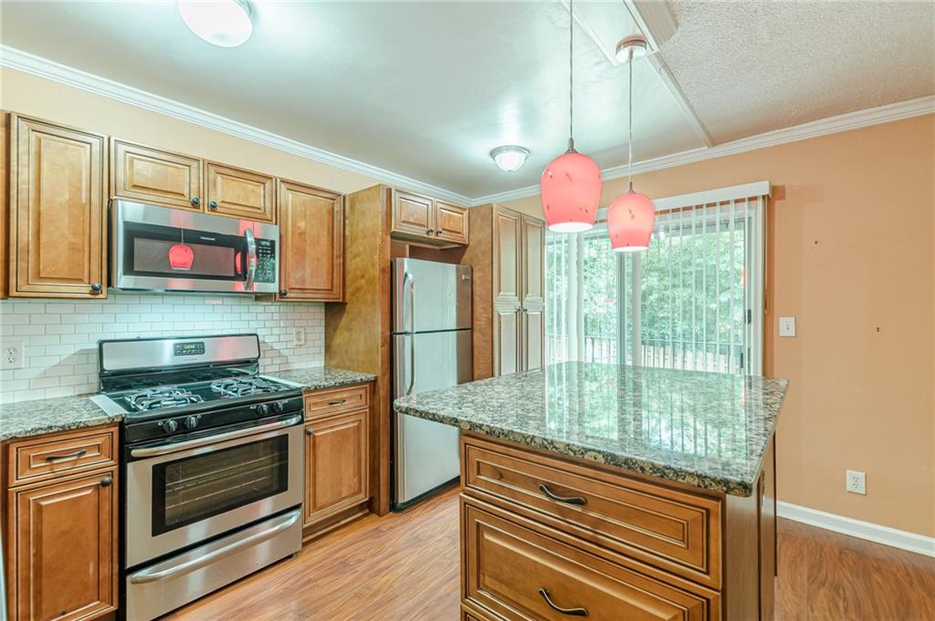 1705 Monroe Drive Northeast, Unit C05 Atlanta, GA 30324 - Photo 19 of 29 a kitchen with stainless steel appliances granite countertop a stove and a refrigerator