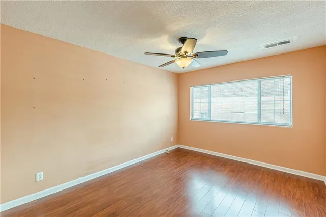a view of a big room with wooden floor and windows