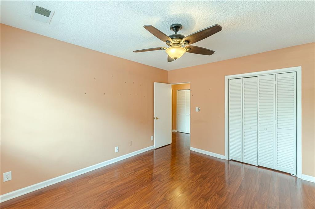 1705 Monroe Drive Northeast, Unit C05 Atlanta, GA 30324 - Photo 10 of 29 a view of an empty room with wooden floor and a ceiling fan