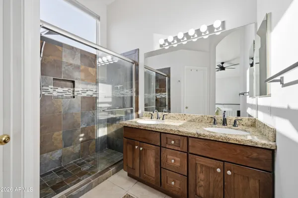 a bathroom with a granite countertop sink mirror and shower