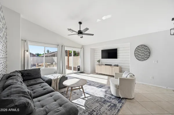 a living room with furniture a flat screen tv and wall paintings