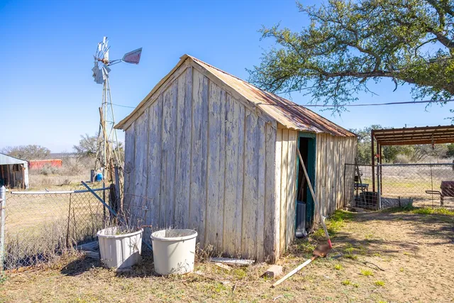 a view of a yard with wooden fence