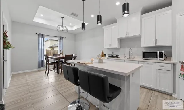 a kitchen with kitchen island granite countertop a sink a counter space appliances and cabinets