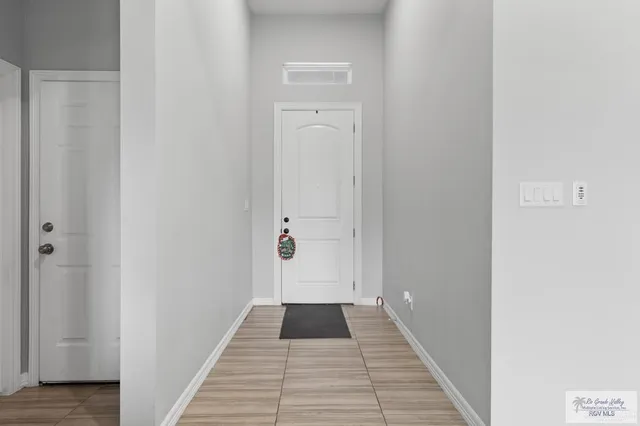 a view of a hallway with wooden floor and a bathroom