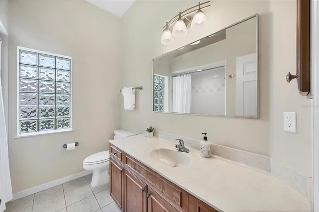 a bathroom with a sink a toilet and a mirror