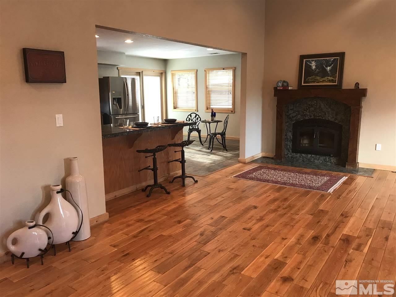 21715 Sazarac Road Reno, NV 89521 - Photo 13 of 25 a living room with furniture a fireplace and a flat screen tv