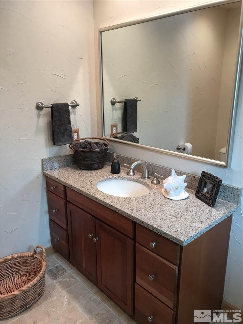 21715 Sazarac Road Reno, NV 89521 - Photo 16 of 25 a bathroom with a granite countertop sink and a mirror