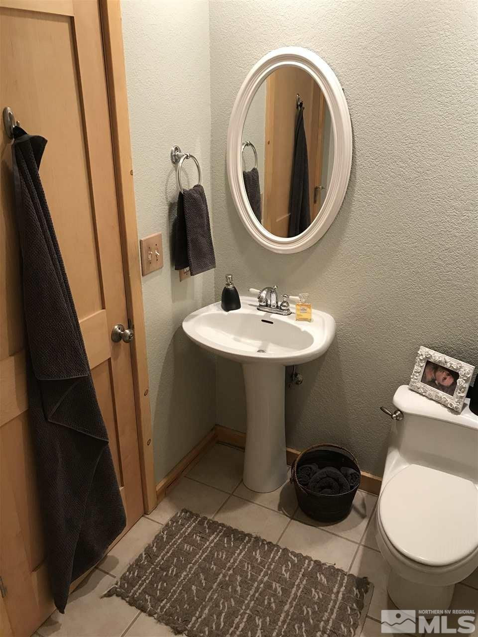 21715 Sazarac Road Reno, NV 89521 - Photo 18 of 25 a bathroom with a toilet a sink and a mirror